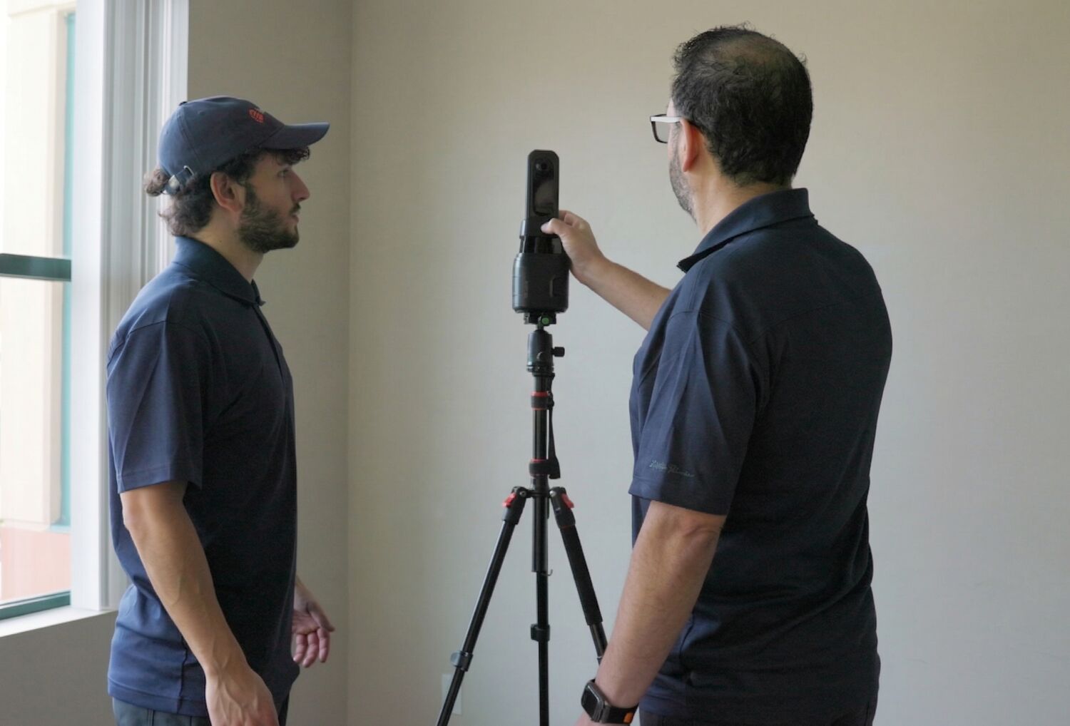 Two PlanBase 360 team members reviewing scan data together on a laptop