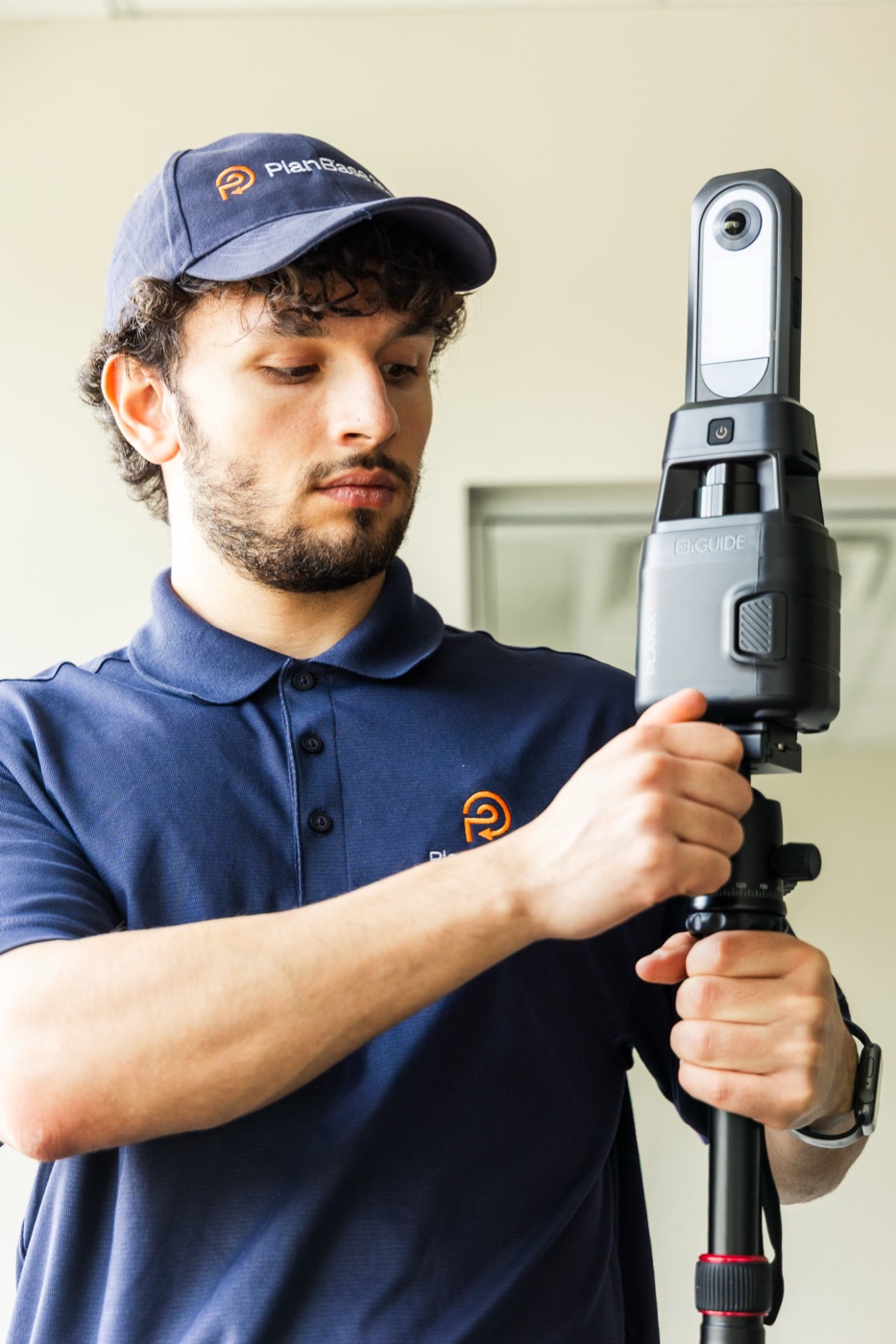 PlanBase 360 operator mounting the iGUIDE PLANIX scanner onto a tripod in a commercial interior