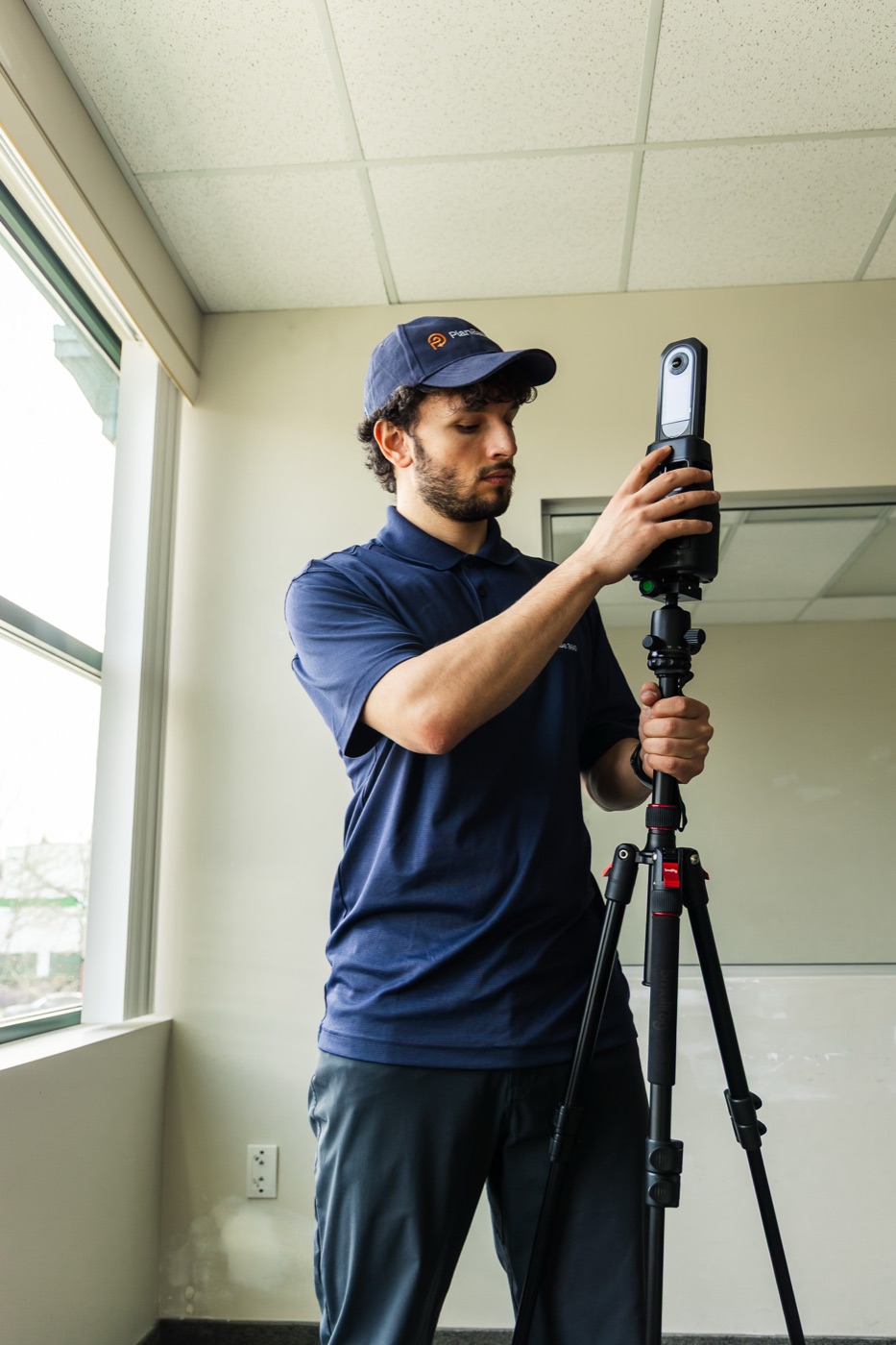 Operator setting up a LiDAR scanner to capture an office interior for a BIM model
